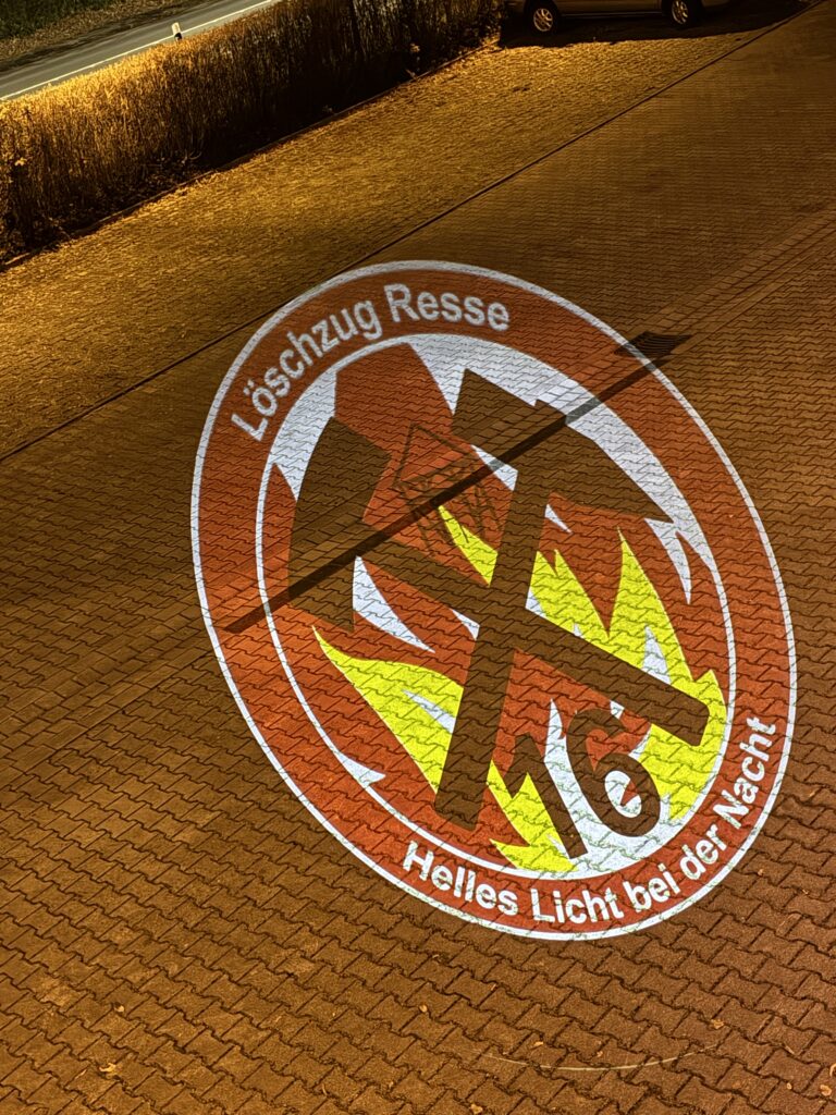 Löschzug-Logo auf den Wachhof projiziert.